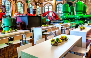 Pumphalle mit Hochtischen und Stühlen