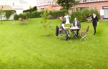 Tagungsgarten mit Grünfläche und kostenfreiem WiFi für Gruppenarbeit und Tagungspausen.