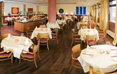 Raum mit bedeckten Tischen und Bestuhlung 