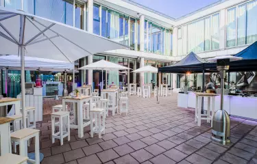 Meeting Guide Berlin Cafe Moskau Innenhof mit Sonnenschirmen und Stehtischen