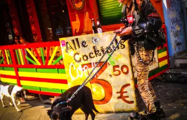 Smartphone-Jagd mit Punker und Hund vor alternativer Kneipe