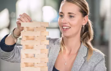 Frau baut einen Dominoturm