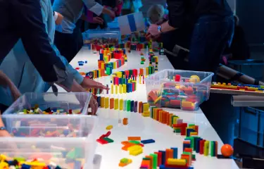 Meeting Guide Berlin Team Spirit Team builds a row of dominos on a table