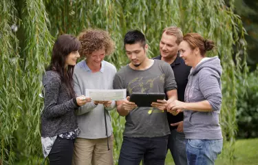 Meeting Guide Berlin Team Spirit Team with iPad and map in the green