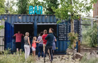People standing in line in front of the bar in the garden