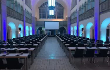 Blick in die leere Haupthalle des Stadtbad Orderberger mit Tischreihen und Stühlen