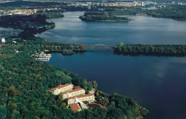 Seminaris SeeHotel Potsdam Birdview, weiter Seeblick und Hotel ragt zwischen Bäumen hervor im Vordergrund