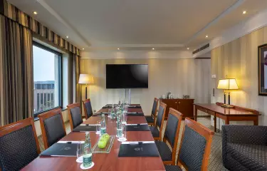 Business Suite mit Tagungstisch, Screen und Platz für 8 Personen 