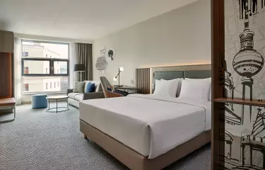 Zimmer mit Bett, Schreibtisch, und Sitzbereich mit Sofa