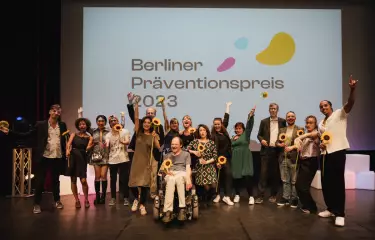 Gruppenfoto der Gewinner:innen des Berliner Präventionspreises 2023 auf der Bühne.
