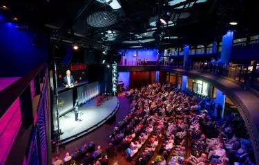Forum des Gasometers, von oben fotografiert, Reihenbestuhlung mit vielen Menschen, Blick auf die Bühne