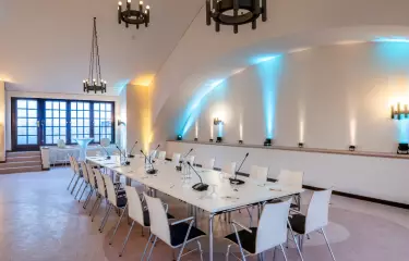 Festsaal bestuhlt für ein Meeting mit Onlineoption 