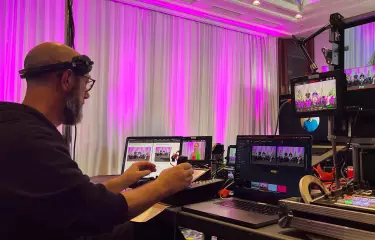 eine Person, die von Streaming-Geräten umgeben ist, steuert eine Kamera.