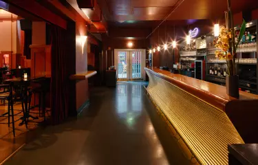 Blick auf den Eingangsbereich mit Bar auf der rechten Seite und Saal zur linken Seite