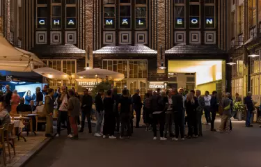 Innenhof mit Blick auf ein Restaurant mit Terasse und Eingang des Chamäleon Theaters