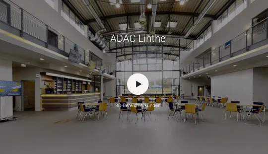 Großer, heller Raum mit Tischen und Stühlen, hohe Fenster, moderne Einrichtung