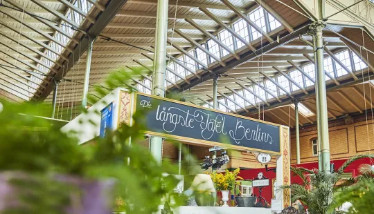Markthalle mit Pflanzen und einem Schild, das handgeschriebenes Menü zeigt