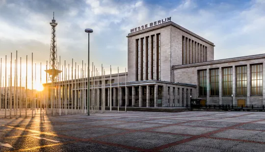 Messe Berlin bei Sonnenaufgang mit Funkturm im Hintergrund.