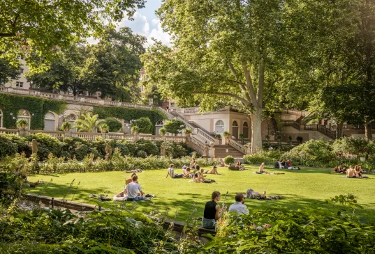Körnerpark in Berlin Neukölln, people sitting on the grass and having a picnic
