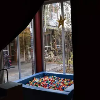 Bällebad vor Fensterscheibe im Mehrgenerationshaus
