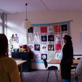 vier Personen schauen sich Kunst im Mehrgenerationshaus an