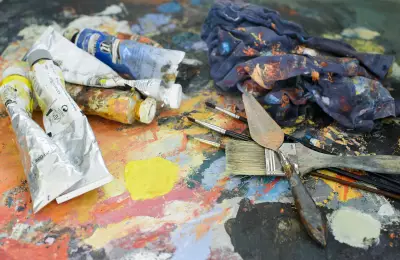 Paint tubes, spatulas and brushes in the studio of a painter
