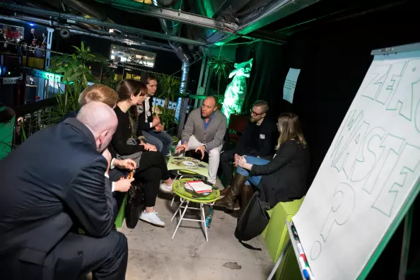 Menschen sitzen in kleiner Gruppe zusammen und sprechen zum Thema Nachhaltigkeit