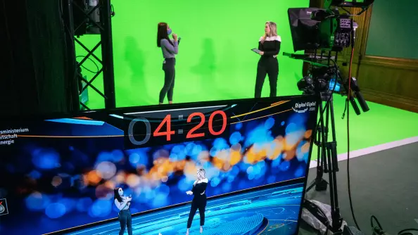 Presenters in a greenbox during an online event