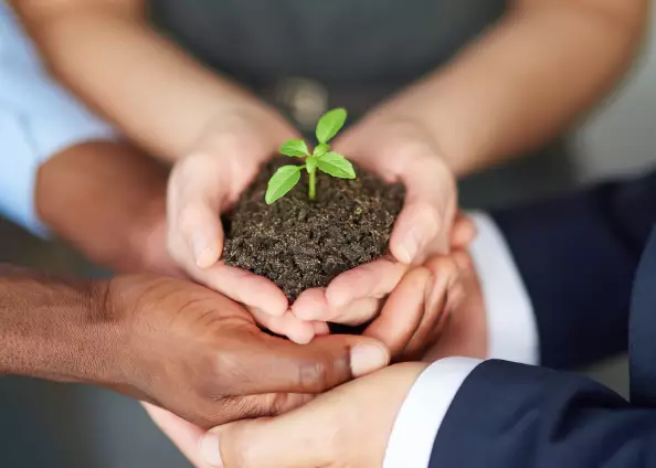 Trend towards sustainable give-aways - be creative Participants of a Green Event in Berlin holding earth with a small green plant.