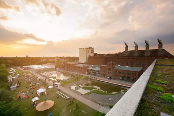 Green meadow of the event location Malzfabrik in Berlin Schöneberg at sunset.