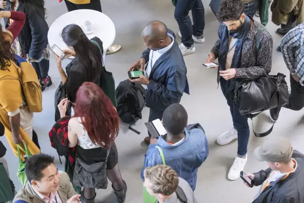 Businessleute benutzen ihr Smartphone bei einer Konferenz Businessleute benutzen ihr Smartphone bei einer Konferenz um Nachrichten zu erhalten