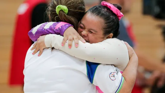 Zwei Athletinnen umarmen sich bei den Special Olympics World Games 2023 und strahlen vor Freude.