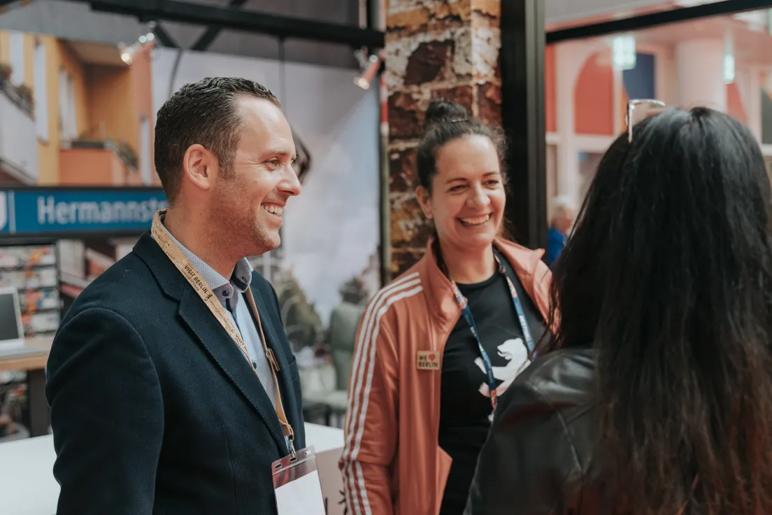 Employees of the visitBerlin Berlin Convention Office talking to partners at a trade fair