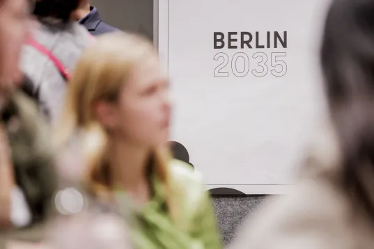 Participants at an event at the Berlin stand, with the Berlin logo and the year 2035 in the background