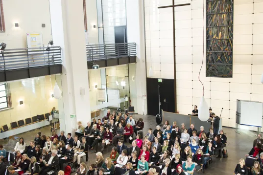 Green Meeting” congress by Visit Berlin at the Umweltforum Friedrichshain. Many people are seated in the church, attending the even
