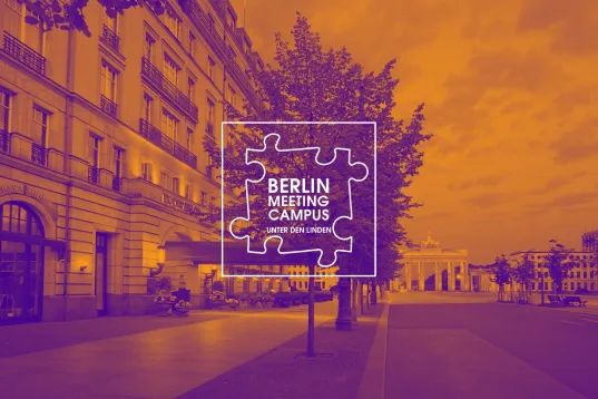 Unter den Linden street in Berlin with Brandenburg Gate and Berlin Meeting Campus logo