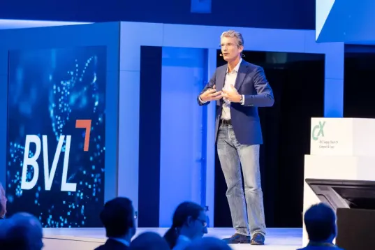 A speaker on a stage marked with the letters ‘BVL’. 