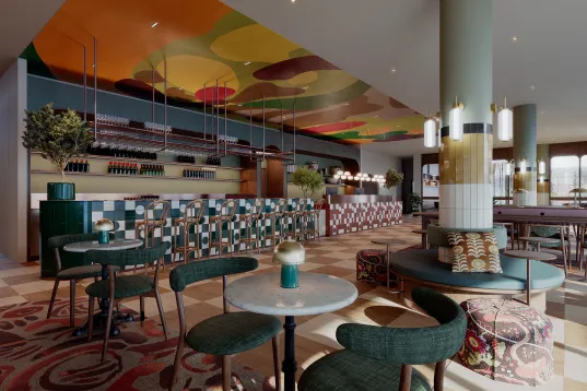 Modernes Café mit buntem Deckenmuster, stilvollen Möbeln und gemustertem Boden.