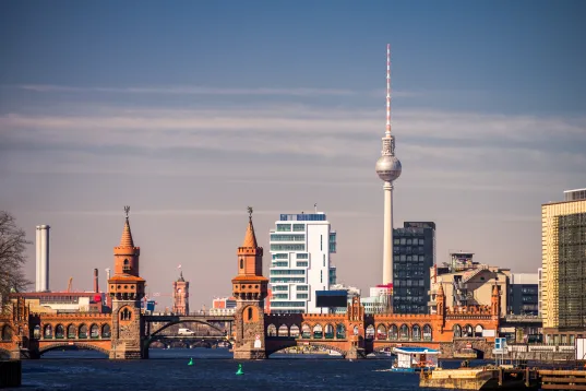 Blick auf die Berliner Skyline mit Oberbaumbrücke und Fernsehturm bei klarem Himmel.