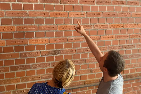 The picture shows two people standing in front of a church.