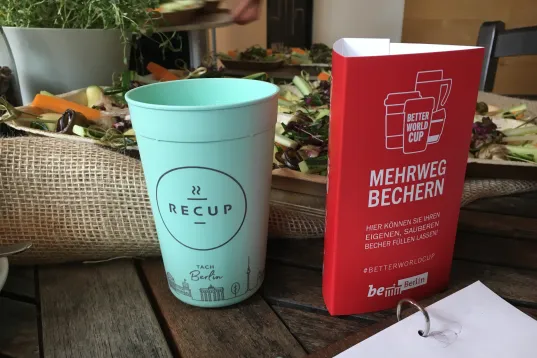 The image shows a reusable cup with the inscription "Better World Cup"
