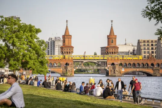 viele Menschen am Spreeufer, im Hintergrund die Oberbaumbrücke