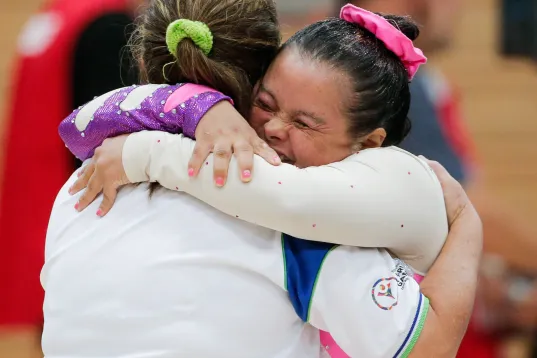 Two athletes embrace with joy at the Special Olympics World Games 2023, beaming with happines