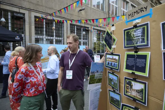 Exhibitor at a trade fair conversing with a lady
