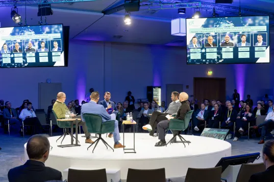 A circular platform where people can chat and participants sit around the stage.