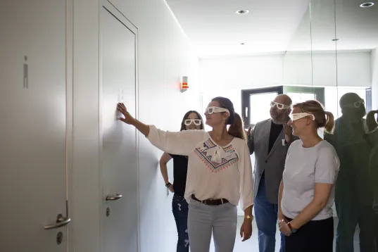 At Visit Berlin’s accessible market day at the Otto Bock Science Center, visitors wearing glasses explore something on the wall by touch.