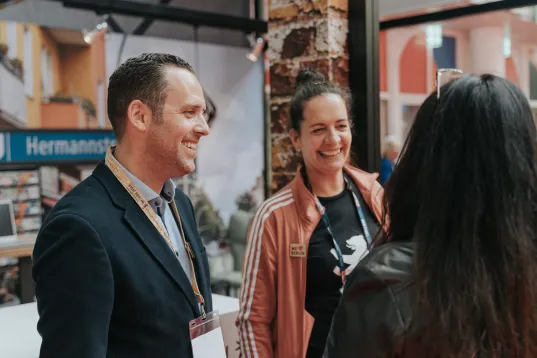 Employees of the visitBerlin Berlin Convention Office talking to partners at a trade fair